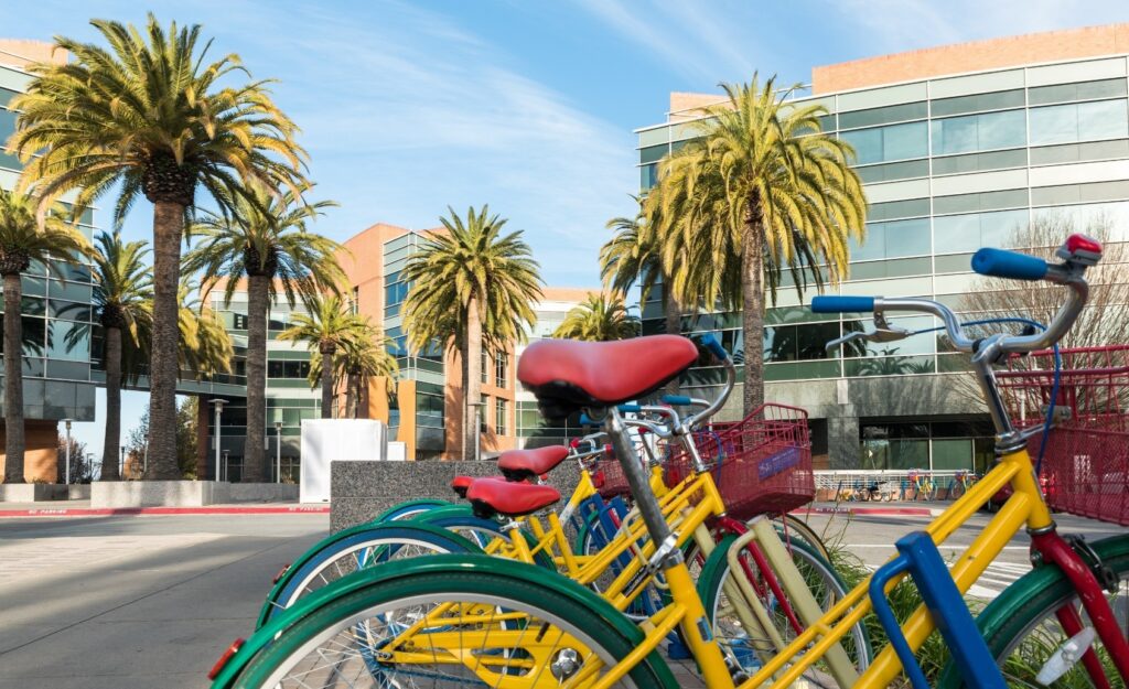 Luxury Apartments for Rent in Mountain View, CA - Avelle - Outdoor Bike Rack with View of Palm Trees and Apartment Buildings in the Background.